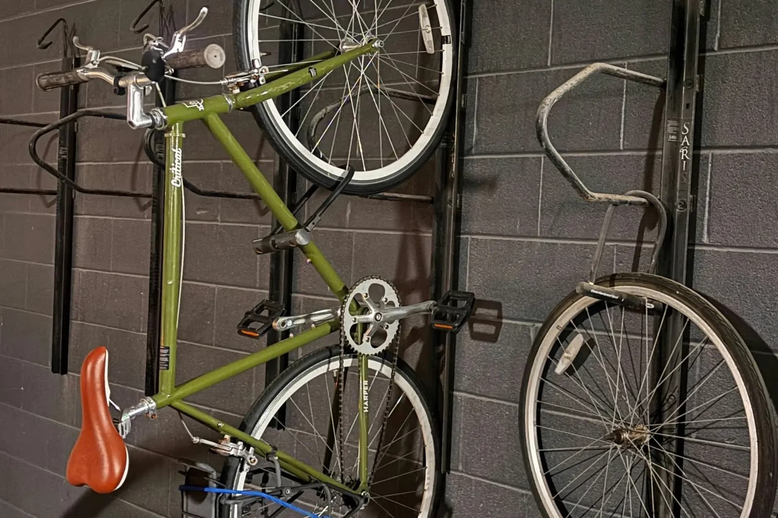 Wall-mounted vertical bike hooks in a residential parking garage bike storage area in Canada