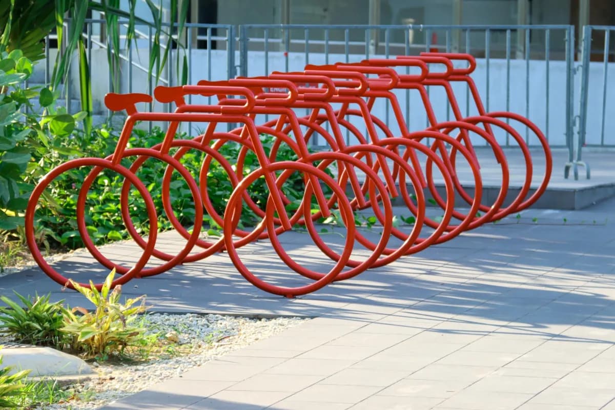 Custom decorative red bike-shaped bike racks installed outside a building entrance in Canada