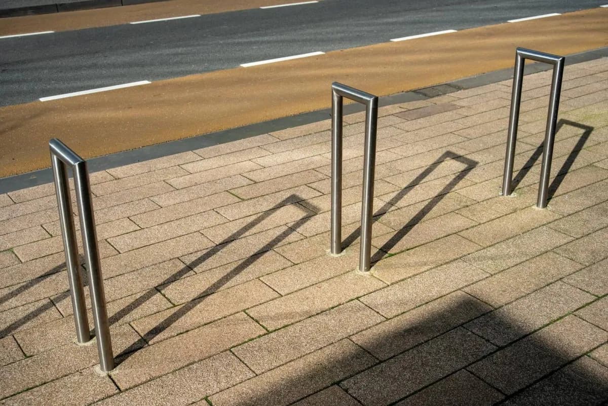 Outdoor commercial bike racks with yellow upper tier and steel inverted-U racks at ground level in Canada