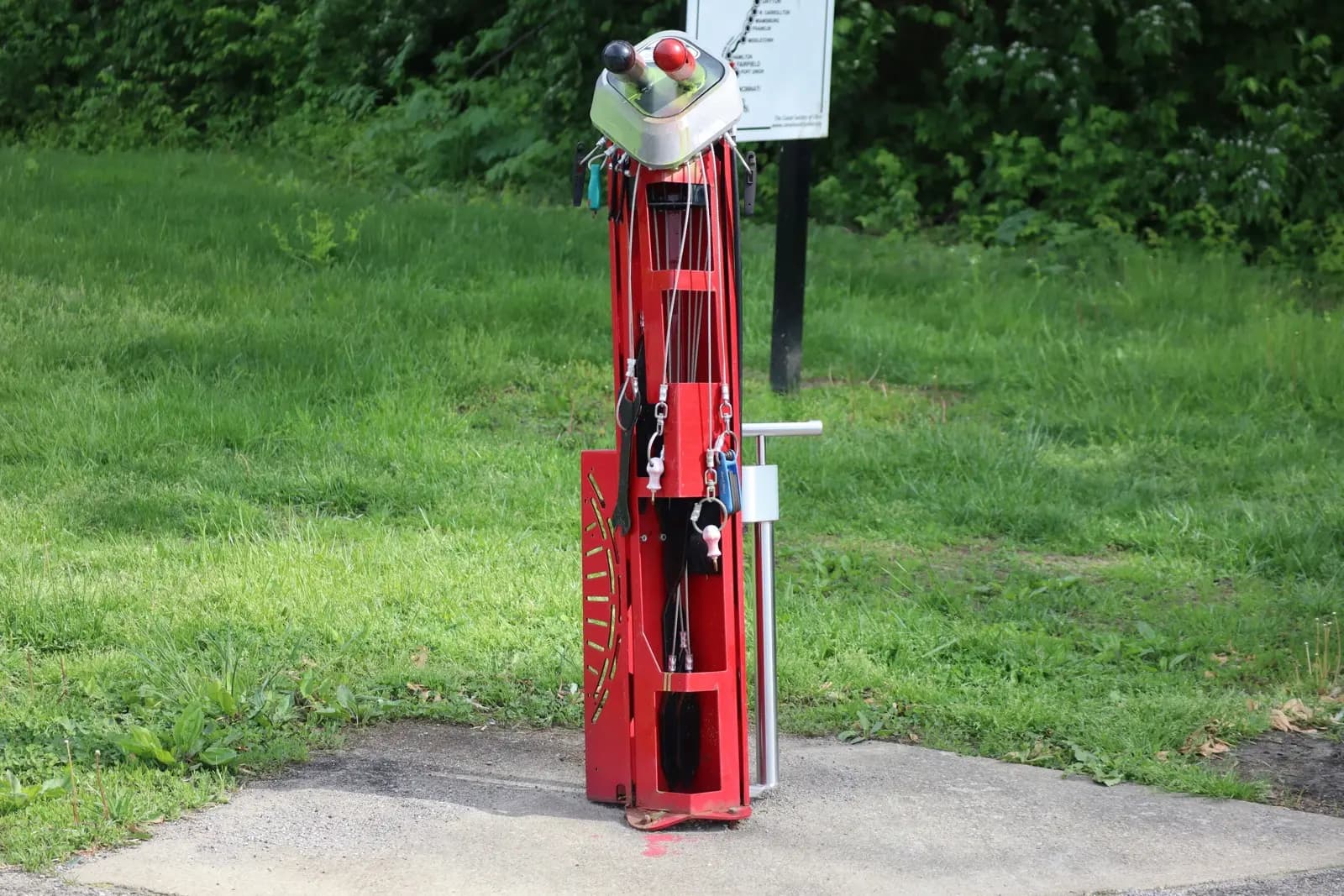 Public bike repair station with built-in tools and air pump installed on a park pathway in Canada