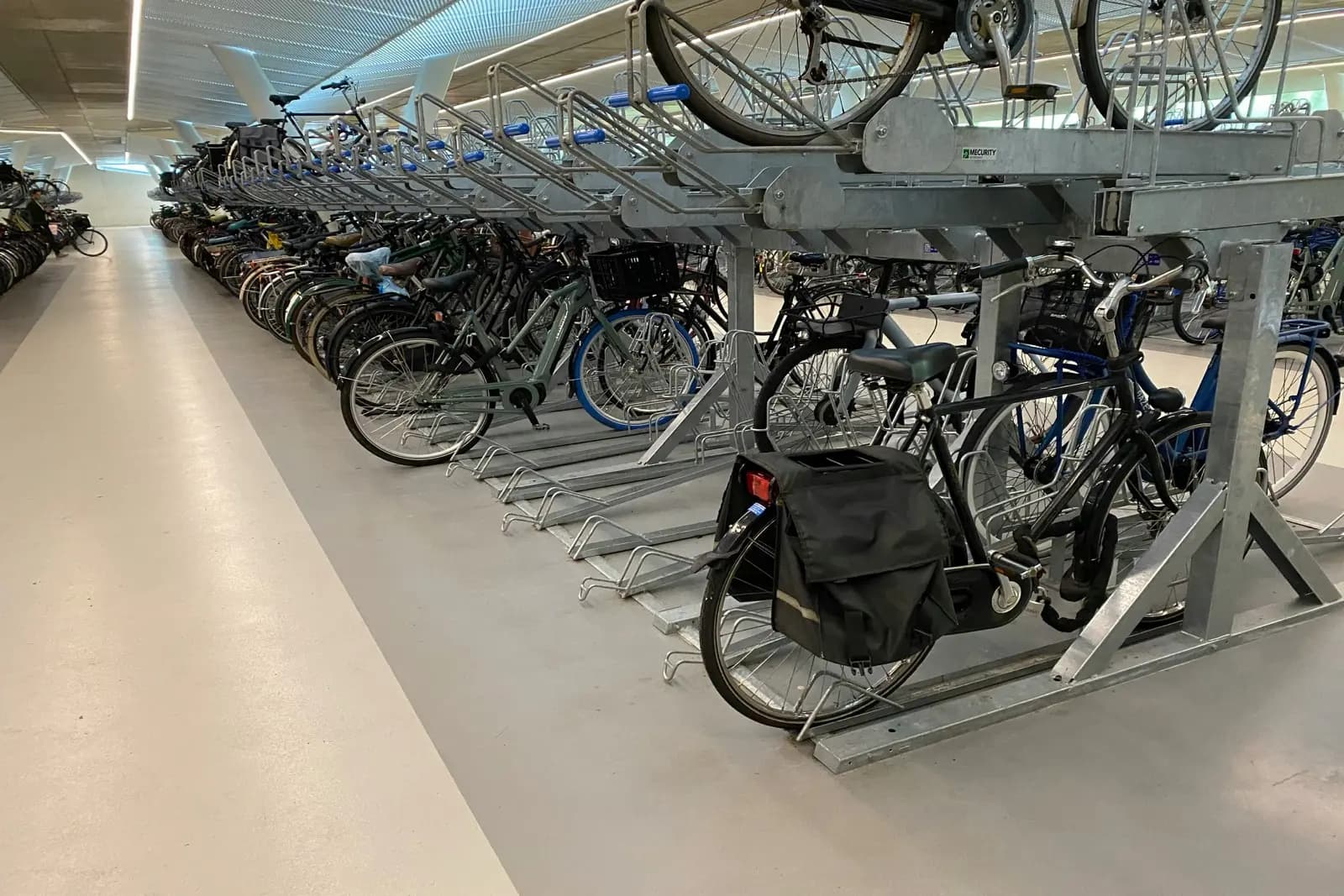 Two-tier double-decker bike rack system with upper and lower parking levels in an indoor facility in Canada
