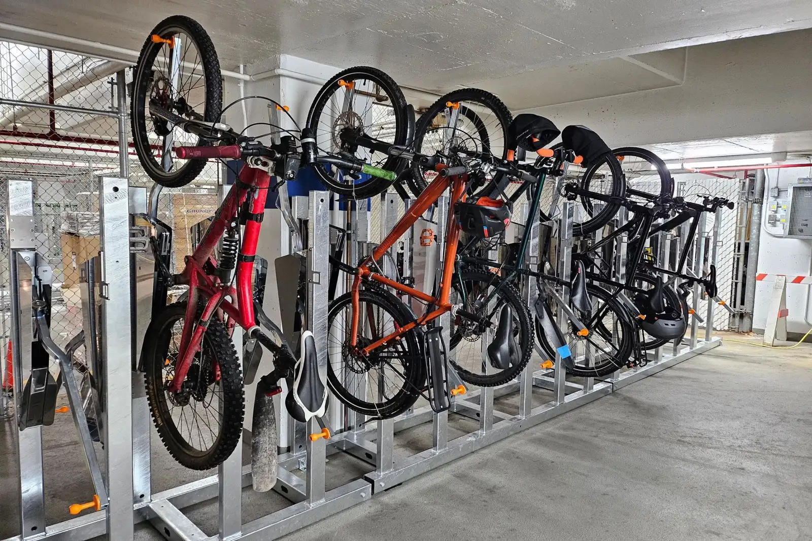 Vertical bike racks with e-bikes including charging outlets in a Canadian condo bike room